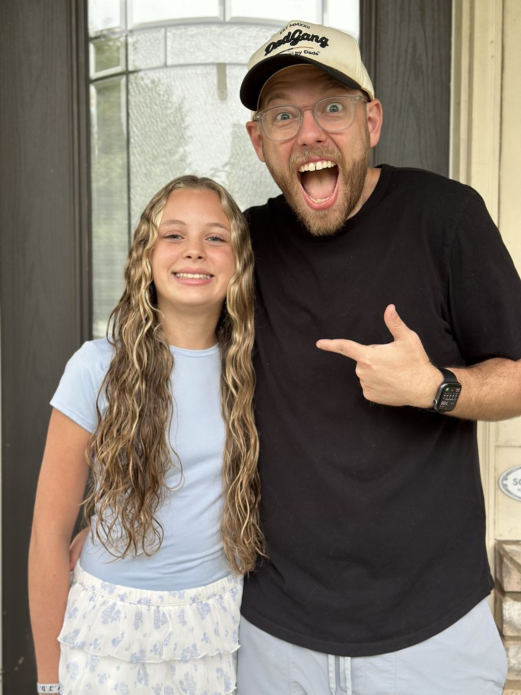 Aaron in a DadGang hat, mugging for the camera with his daughter