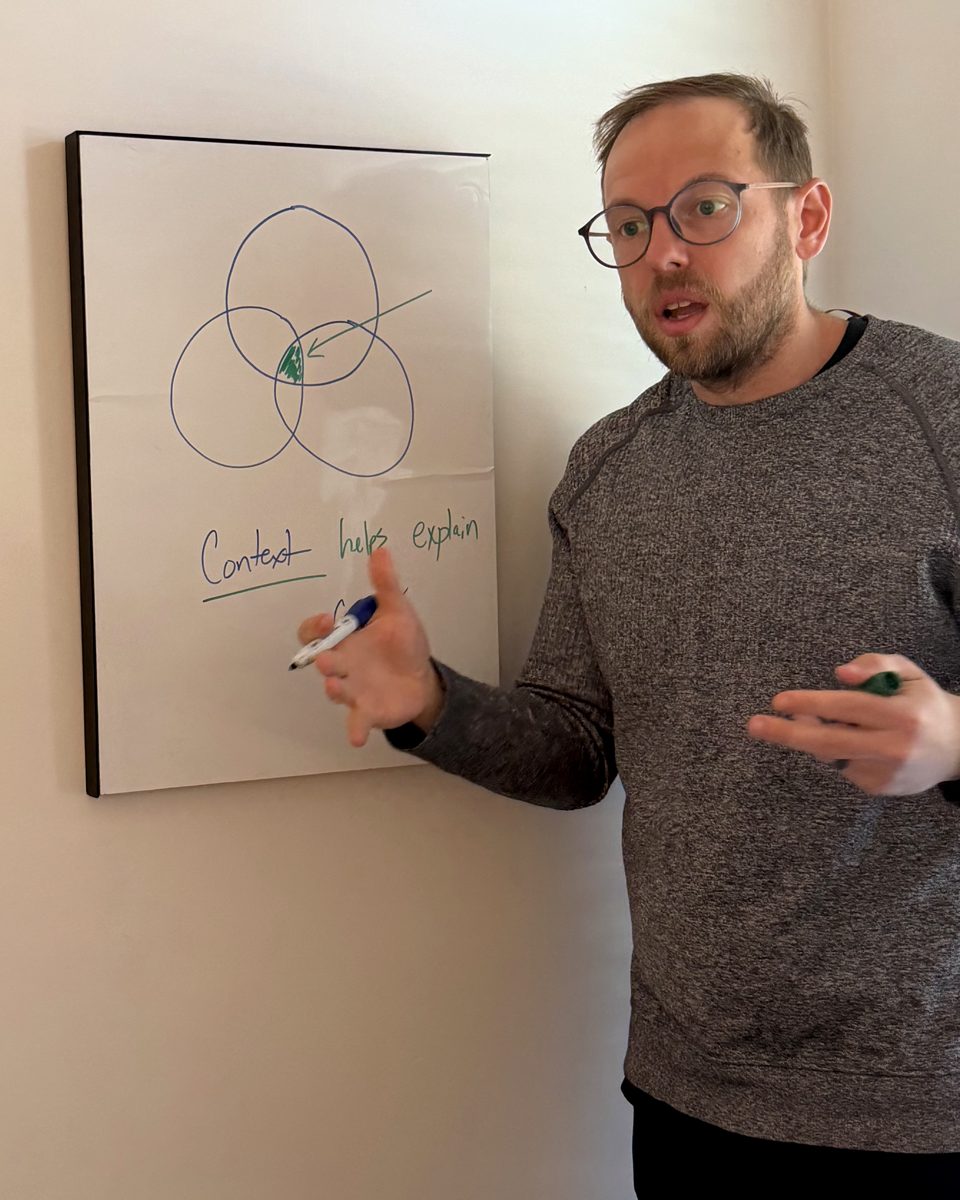 Aaron explaining his diagram at a whiteboard